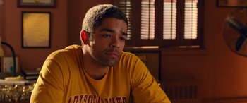 Movie still from “Noelle” (2019), directed by Marc Lawrence – A young man in a yellow shirt is sitting in a room; Close Up shot, Over the shoulder angle