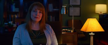 Movie still from “Noelle” (2019), directed by Marc Lawrence – A woman sitting in a chair in front of a lamp; Close Up shot, Over the shoulder angle