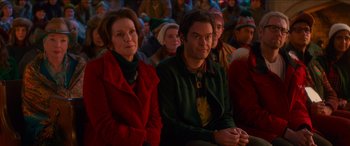 Movie still from “Noelle” (2019), directed by Marc Lawrence – A man and a woman sitting in front of a group of people; Medium shot, Over the shoulder angle