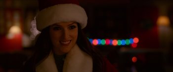 Movie still from “Noelle” (2019), directed by Marc Lawrence – A woman wearing a santa hat and a red coat; Close Up shot, Overhead angle