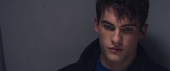 Movie still from “Notorious Nick” (2021), directed by Aaron Leong – A person wearing a black jacket; Close Up shot, Over the shoulder angle