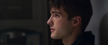 Movie still from “Notorious Nick” (2021), directed by Aaron Leong – A person's face looking to the side; Close Up shot, Over the shoulder angle