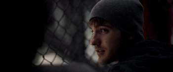 Movie still from “Notorious Nick” (2021), directed by Aaron Leong – A person wearing a hat; Close Up shot, Over the shoulder angle