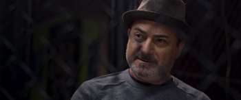 Movie still from “Notorious Nick” (2021), directed by Aaron Leong – A person wearing a hat; Close Up shot, Over the shoulder angle