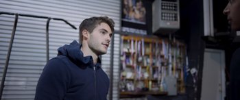 Movie still from “Notorious Nick” (2021), directed by Aaron Leong – A man standing in front of a wall of mirrors; Medium shot, Over the shoulder angle