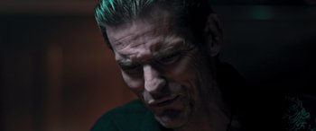 Movie still from “Notorious Nick” (2021), directed by Aaron Leong – A person with a green shirt; Close Up shot, Low angle
