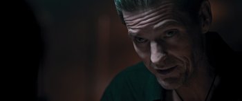 Movie still from “Notorious Nick” (2021), directed by Aaron Leong – A person looking at the camera; Close Up shot, Over the shoulder angle