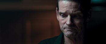 Movie still from “Notorious Nick” (2021), directed by Aaron Leong – A person with a serious look on his face; Close Up shot, Over the shoulder angle