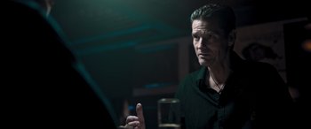 Movie still from “Notorious Nick” (2021), directed by Aaron Leong – A man is sitting at a table with a glass of beer; Close Up shot, Over the shoulder angle