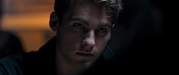 Movie still from “Notorious Nick” (2021), directed by Aaron Leong – A young man's face in the dark; Close Up shot, Low angle