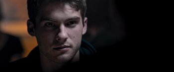 Movie still from “Notorious Nick” (2021), directed by Aaron Leong – A young man's face in the dark; Close Up shot, Over the shoulder angle