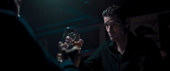 Movie still from “Notorious Nick” (2021), directed by Aaron Leong – A man taking a picture of himself holding a glass of wine; Close Up shot, Over the shoulder angle