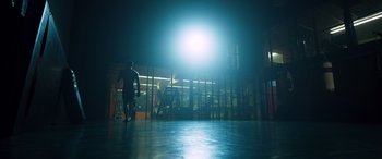 Movie still from “Notorious Nick” (2021), directed by Aaron Leong – A man standing in front of a building at night; Wide shot, Low angle