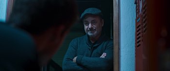 Movie still from “Notorious Nick” (2021), directed by Aaron Leong – A man with a beard and a hat looking at himself in a mirror; Close Up shot, Over the shoulder angle