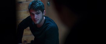 Movie still from “Notorious Nick” (2021), directed by Aaron Leong – A man in a black shirt is looking at the camera; Close Up shot, Over the shoulder angle