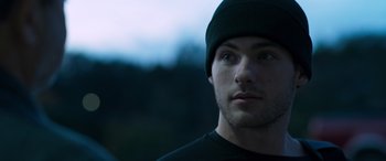 Movie still from “Notorious Nick” (2021), directed by Aaron Leong – A person wearing a hat; Close Up shot, Low angle