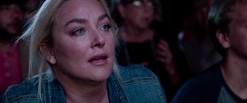 Movie still from “Notorious Nick” (2021), directed by Aaron Leong – A woman is looking at something in the distance; Close Up shot, Over the shoulder angle