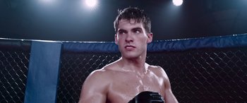 Movie still from “Notorious Nick” (2021), directed by Aaron Leong – A young man in a boxing ring with his hands in his gloves; Close Up shot, Low angle