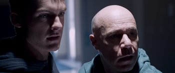Movie still from “Notorious Nick” (2021), directed by Aaron Leong – A man with a bald head is looking at another man with short hair; Close Up shot, Over the shoulder angle