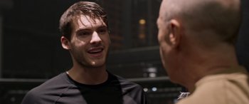 Movie still from “Notorious Nick” (2021), directed by Aaron Leong – A man talking to another man in front of a building; Close Up shot, Over the shoulder angle