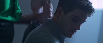 Movie still from “Notorious Nick” (2021), directed by Aaron Leong – Two men are standing in a dark room; Close Up shot, Over the shoulder angle
