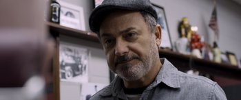 Movie still from “Notorious Nick” (2021), directed by Aaron Leong – A person wearing a hat; Close Up shot, Low angle