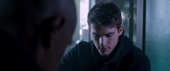 Movie still from “Notorious Nick” (2021), directed by Aaron Leong – A man sitting down looking down at his face; Close Up shot, Over the shoulder angle