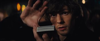 Movie still from “Now You See Me” (2013), directed by Louis Leterrier – A man holding a stack of papers in front of his face; Close Up shot, Overhead angle