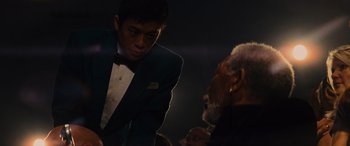 A man in a tuxedo talking to an older man