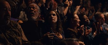 Movie still from “Now You See Me” (2013), directed by Louis Leterrier – A group of people sitting in a room; Medium shot, Over the shoulder angle