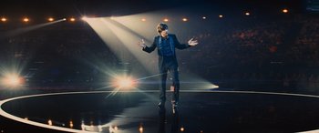 Movie still from “Now You See Me” (2013), directed by Louis Leterrier – A man standing on a skateboard on a stage; Wide shot, High angle