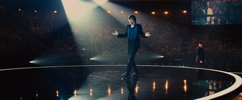 Movie still from “Now You See Me” (2013), directed by Louis Leterrier – A man standing on a stage in front of a crowd; Wide shot, High angle