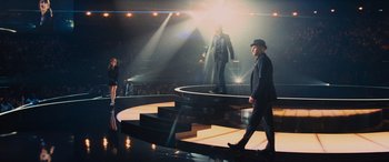 Movie still from “Now You See Me” (2013), directed by Louis Leterrier – A man and a woman are walking on a stage; Wide shot, Low angle