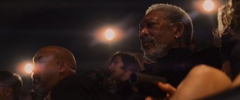 Movie still from “Now You See Me” (2013), directed by Louis Leterrier – An older man with a gray beard is holding a microphone; Close Up shot, Over the shoulder angle