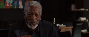 Movie still from “Now You See Me” (2013), directed by Louis Leterrier – An older man with a gray beard is smiling for the camera; Close Up shot, Over the shoulder angle