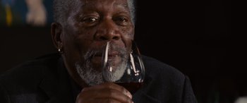 Movie still from “Now You See Me” (2013), directed by Louis Leterrier – An older man holding a glass of red wine; Close Up shot, Over the shoulder angle