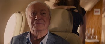 Movie still from “Now You See Me” (2013), directed by Louis Leterrier – An older man sitting in the back seat of a car; Close Up shot, Over the shoulder angle
