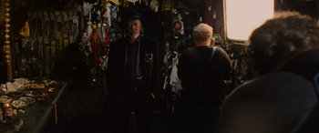 Movie still from “Now You See Me” (2013), directed by Louis Leterrier – A man in a suit standing next to a woman in a hat; Medium shot, Over the shoulder angle