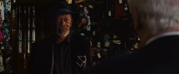 Movie still from “Now You See Me” (2013), directed by Louis Leterrier – An older man wearing a black suit and a black hat; Close Up shot, Over the shoulder angle