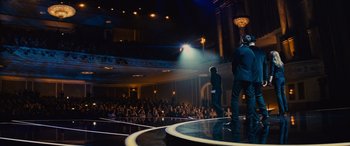 Movie still from “Now You See Me” (2013), directed by Louis Leterrier – Two men stand on a stage in front of an audience; Wide shot, High angle