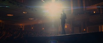 Movie still from “Now You See Me” (2013), directed by Louis Leterrier – A man standing on a stage in front of an audience; Extreme Wide shot, Low angle
