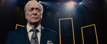 Movie still from “Now You See Me” (2013), directed by Louis Leterrier – An older man wearing a suit and tie in front of a mirror; Close Up shot, Low angle