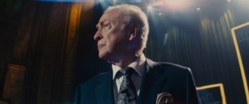 Movie still from “Now You See Me” (2013), directed by Louis Leterrier – An older man wearing a suit and tie; Close Up shot, Low angle