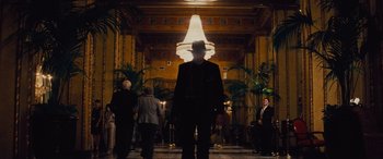 Movie still from “Now You See Me” (2013), directed by Louis Leterrier – A man wearing a hat walking down a hall way; Wide shot, Low angle