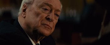 Movie still from “Now You See Me” (2013), directed by Louis Leterrier – An older man wearing a suit and tie looking at the camera; Close Up shot, Over the shoulder angle