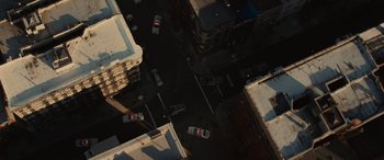 An aerial view of a street with cars driving down it
