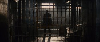 Movie still from “Now You See Me” (2013), directed by Louis Leterrier – A man standing inside of a jail cell; Wide shot, Low angle
