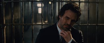 Movie still from “Now You See Me” (2013), directed by Louis Leterrier – A man wearing a suit and tie standing in front of a metal fence; Close Up shot, Low angle