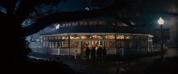 Movie still from “Now You See Me” (2013), directed by Louis Leterrier – A group of people standing in front of a building at night; Extreme Wide shot, High angle