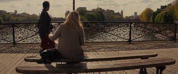 Movie still from “Now You See Me” (2013), directed by Louis Leterrier – A woman sitting on a bench looking out over a river; Wide shot, Over the shoulder angle